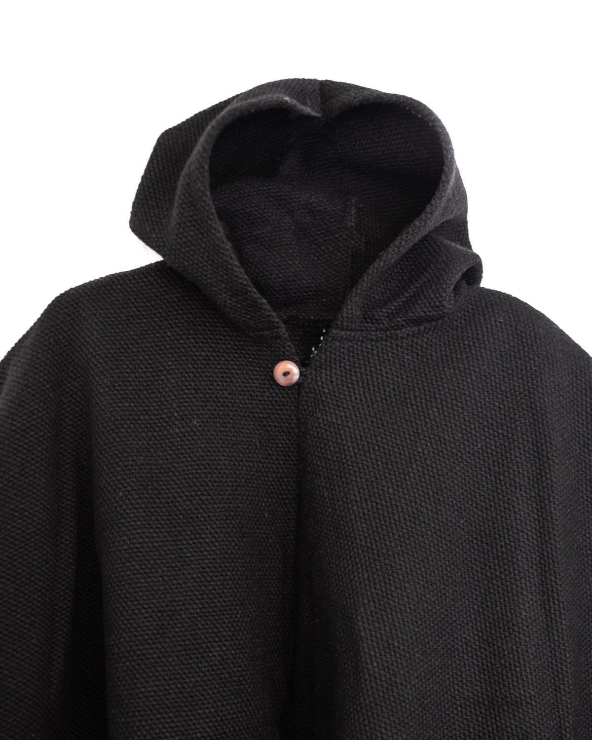 Detalle de gorro de poncho de lana negro artesanal